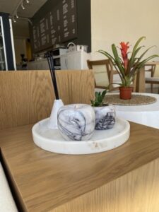 Marble tray styled on a wooden console with a small plant and incense holder