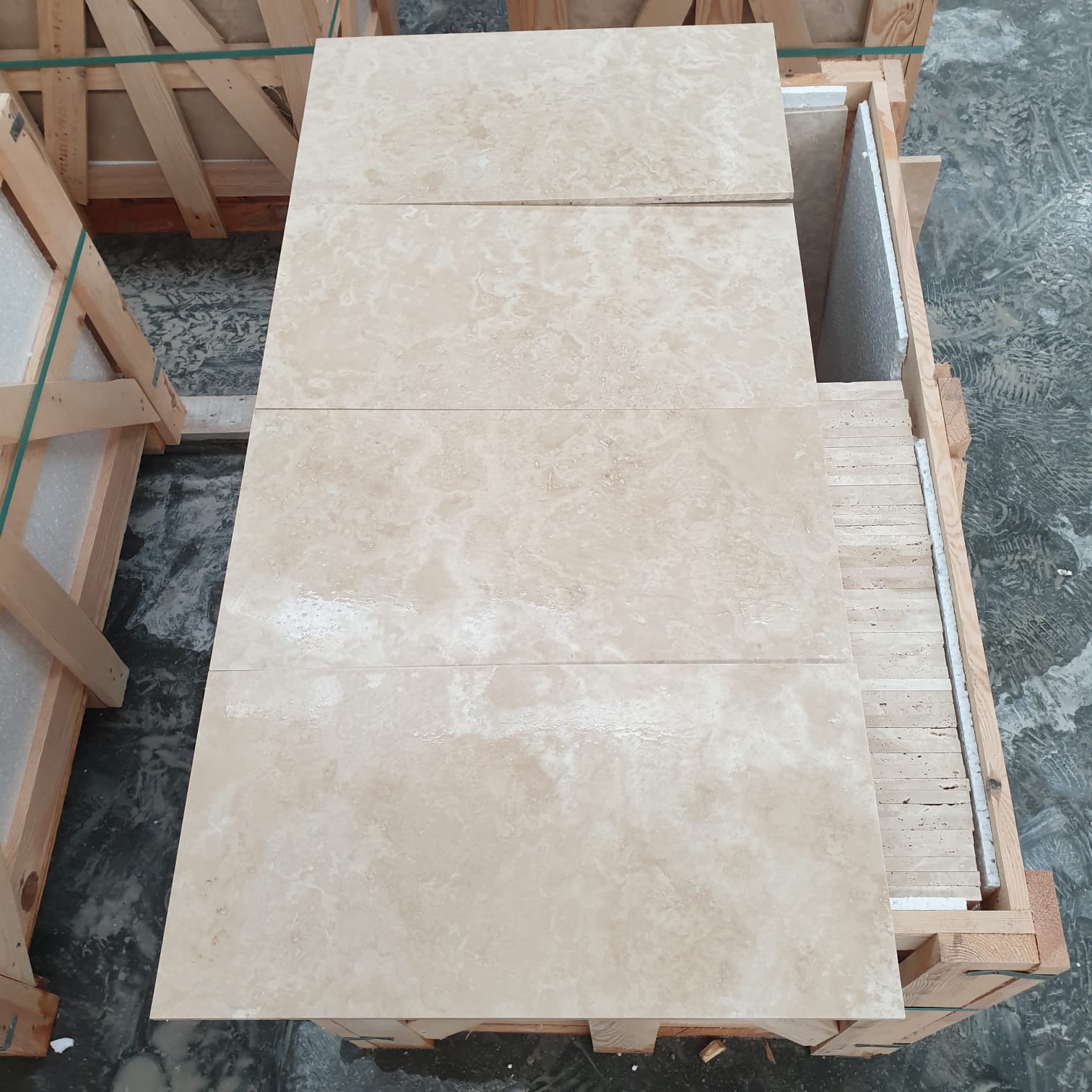 Cement filled beige travertine tiles on a pallet