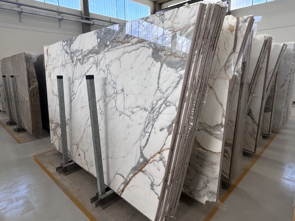 Polished marble slabs on A-frames checked for gloss and finish in a warehouse