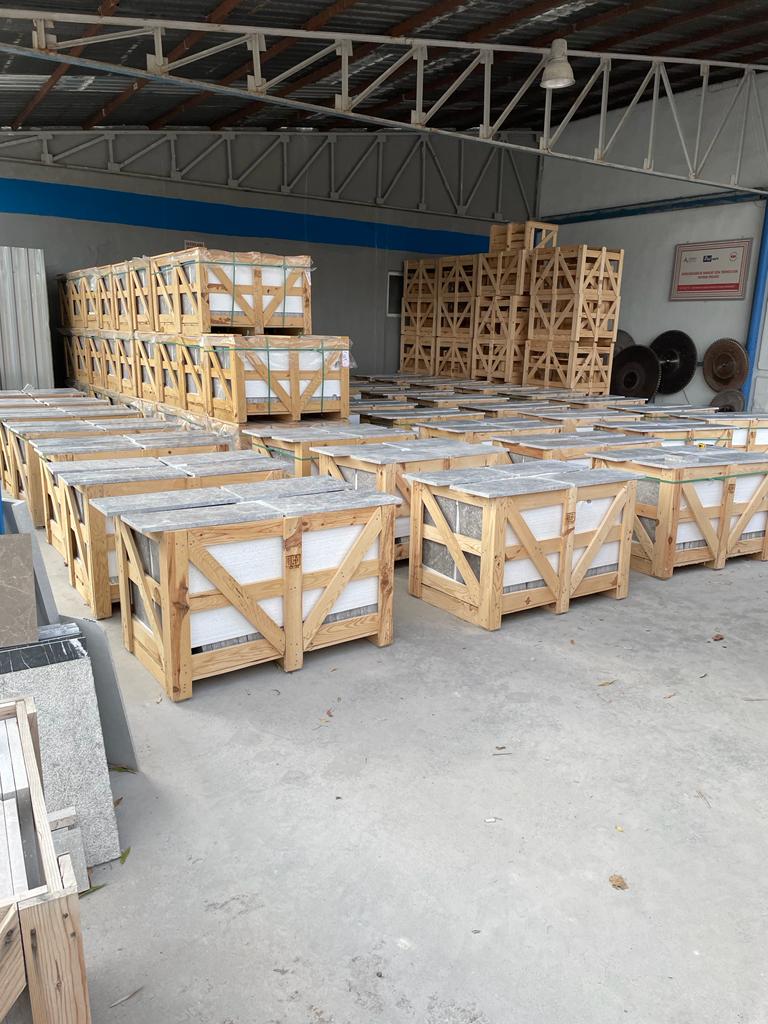 Rows of wooden crates packed with marble tiles inside a factory warehouse in Turkey, ready for selection