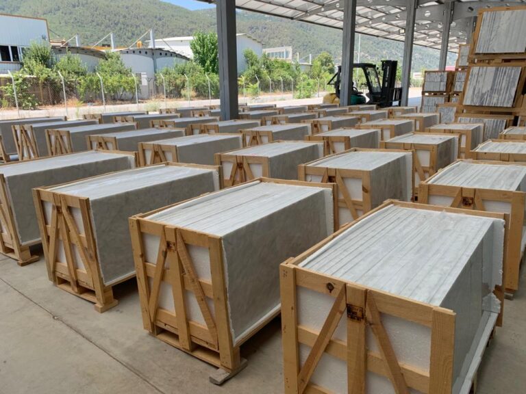 Rows of wooden crates packed with marble tiles in a factory yard in Turkey